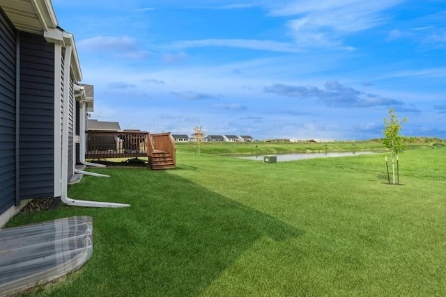 view of yard with a deck with water view