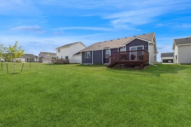 rear view of property featuring fence, a deck, and a yard