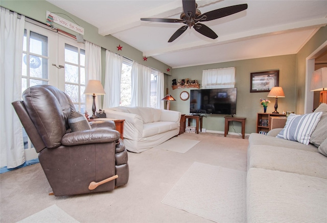 carpeted living area with ceiling fan, baseboards, and beam ceiling