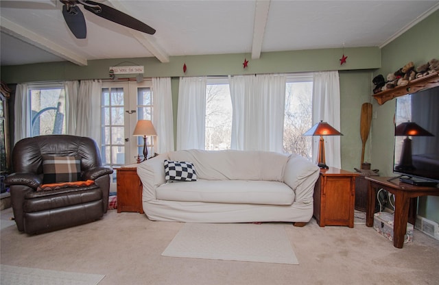 living area featuring carpet floors, a wealth of natural light, beam ceiling, and french doors