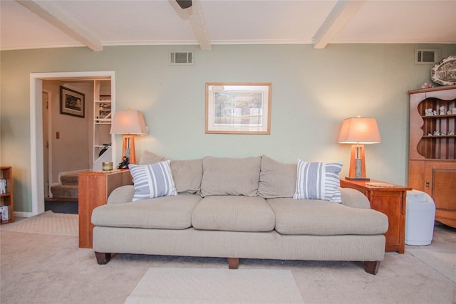 carpeted living area featuring stairs, visible vents, and beam ceiling