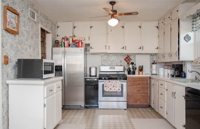 kitchen featuring light countertops, visible vents, appliances with stainless steel finishes, a sink, and wallpapered walls