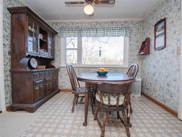 dining room with ornamental molding, ceiling fan, a textured ceiling, baseboards, and wallpapered walls