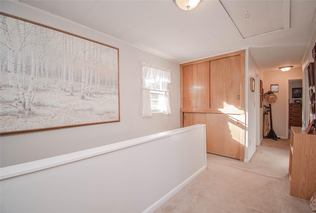 corridor featuring an upstairs landing, attic access, and light colored carpet