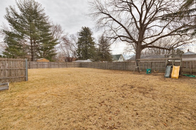 view of yard with a fenced backyard and a playground