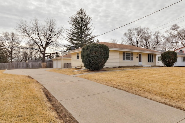 view of front of house featuring central AC unit, a detached garage, fence, and a front lawn