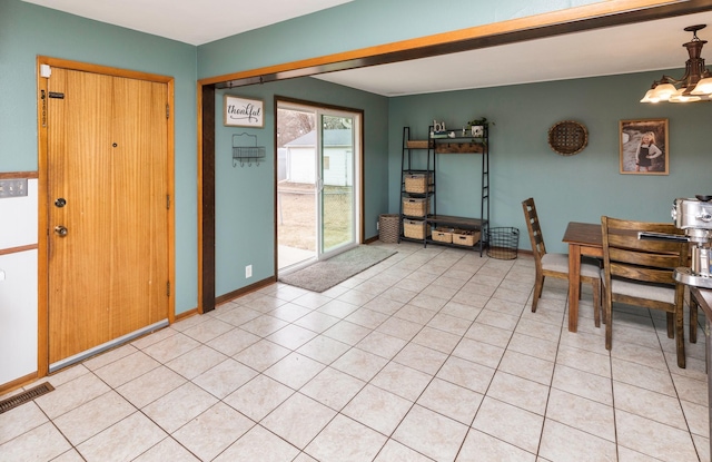 dining area featuring light tile patterned floors, visible vents, a chandelier, and baseboards