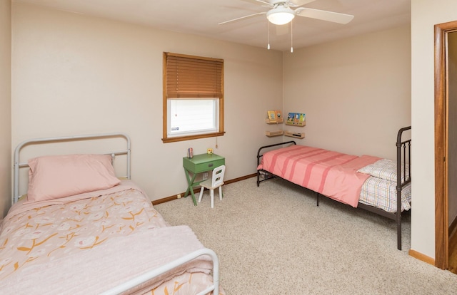 carpeted bedroom with ceiling fan and baseboards