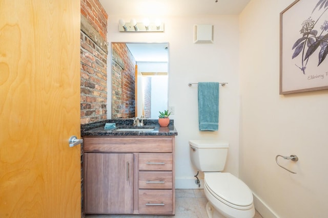 half bathroom with toilet, vanity, brick wall, tile patterned flooring, and baseboards