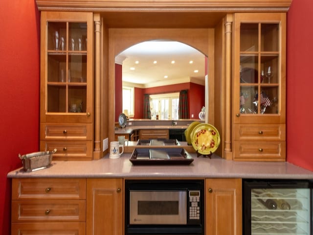 bar with arched walkways, wine cooler, built in microwave, crown molding, and recessed lighting