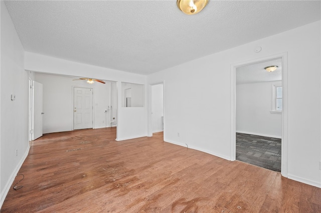 interior space featuring a textured ceiling, a ceiling fan, and wood finished floors