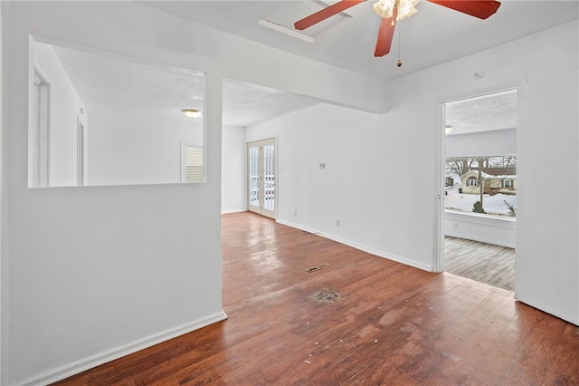 spare room with a healthy amount of sunlight, a textured ceiling, and wood finished floors