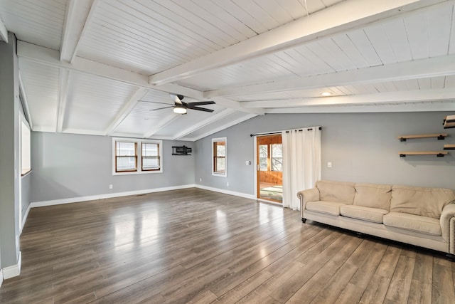 unfurnished living room with lofted ceiling with beams, wood finished floors, a ceiling fan, and baseboards