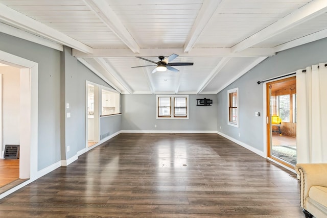 unfurnished room with a healthy amount of sunlight, vaulted ceiling with beams, and baseboards