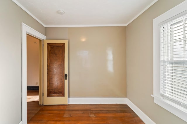 empty room with baseboards, a wealth of natural light, and wood finished floors