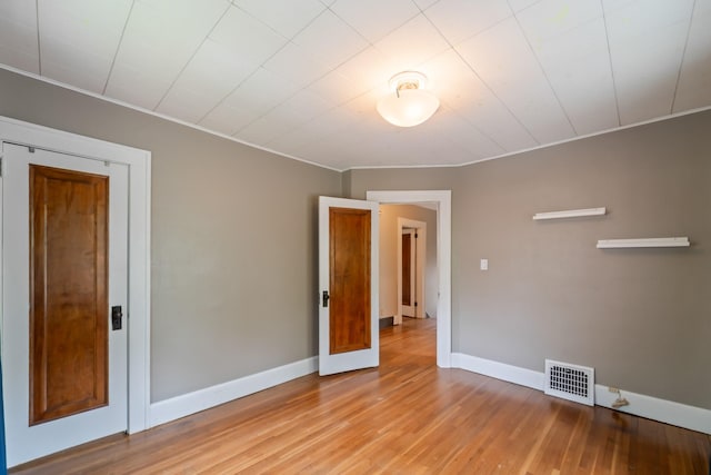 6015 Waterbury Cir, Des Moines, IA 50312 - unfurnished room with baseboards, light wood-type flooring, and ornamental molding