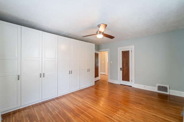 6015 Waterbury Cir, Des Moines, IA 50312 - unfurnished bedroom with baseboards, light wood-style flooring, and ceiling fan