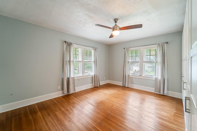 6015 Waterbury Cir, Des Moines, IA 50312 - empty room with plenty of natural light, light wood-style flooring, a ceiling fan, and baseboards