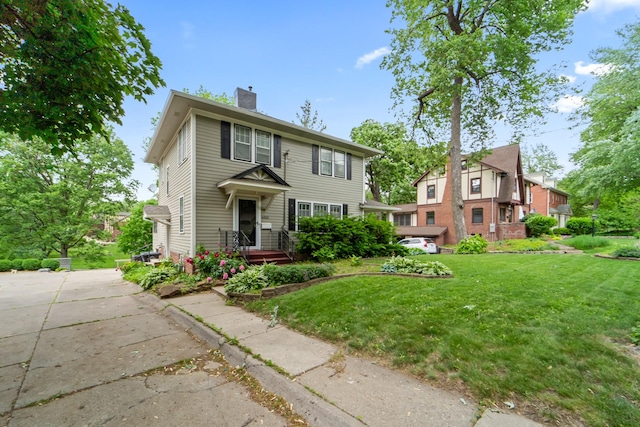 6015 Waterbury Cir, Des Moines, IA 50312 - view of front of property featuring a chimney and a front yard