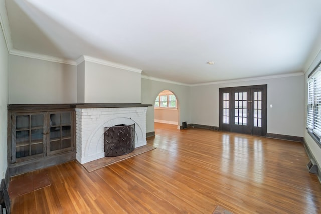 6015 Waterbury Cir, Des Moines, IA 50312 - unfurnished living room with a brick fireplace, wood finished floors, baseboards, and crown molding