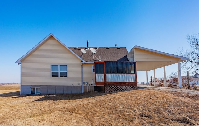 back of property featuring a sunroom and a lawn