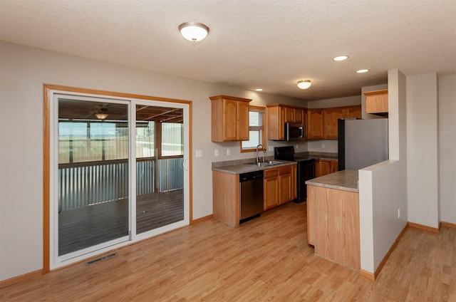 kitchen with baseboards, visible vents, appliances with stainless steel finishes, light wood-type flooring, and a sink