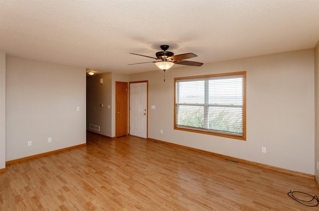 unfurnished room with visible vents, light wood-style flooring, and a textured ceiling