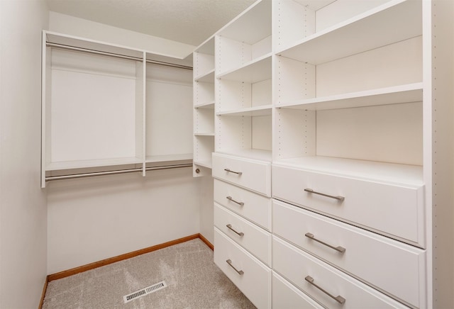 walk in closet with light carpet and visible vents