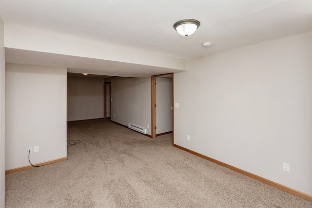 finished basement featuring a baseboard radiator, light colored carpet, and baseboards