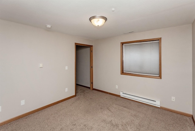 carpeted spare room with a baseboard heating unit and baseboards