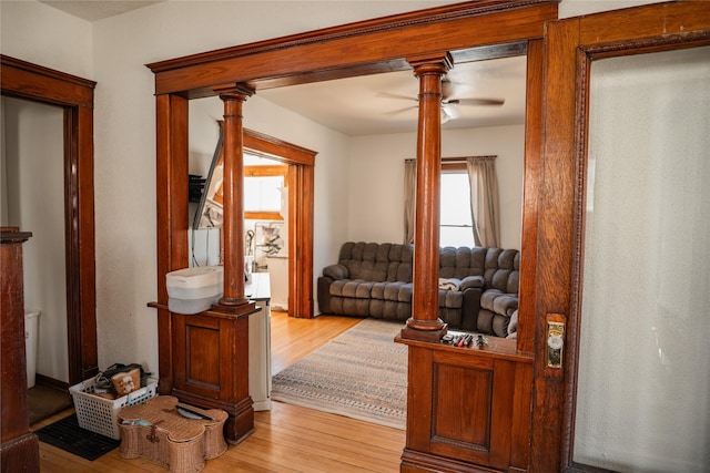 interior space featuring light wood-type flooring and decorative columns