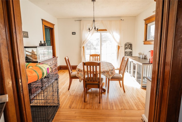 dining space with a textured ceiling, hardwood / wood-style flooring, and baseboards