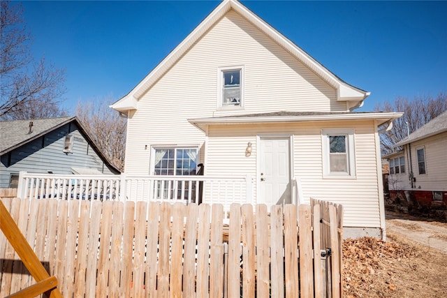 back of property featuring a gate and fence