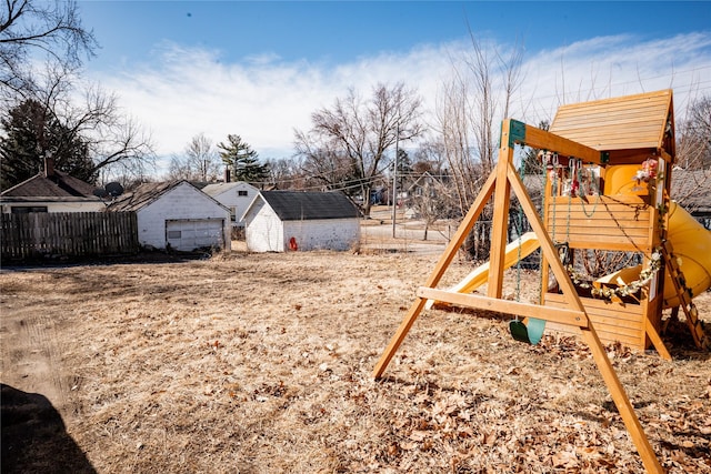 view of yard with an outbuilding, a playground, and fence