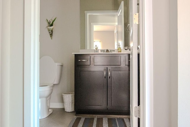 bathroom featuring tile patterned flooring, baseboards, vanity, and toilet