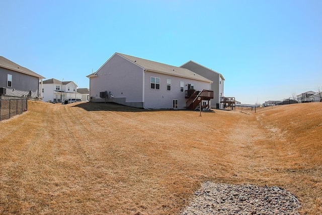 rear view of house with a lawn and fence