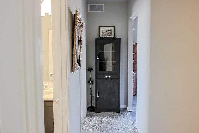 hall featuring visible vents and baseboards