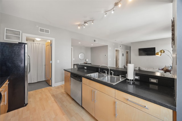 kitchen featuring appliances with stainless steel finishes, visible vents, a sink, and light brown cabinets