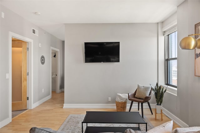 living area with light wood-type flooring, baseboards, and visible vents