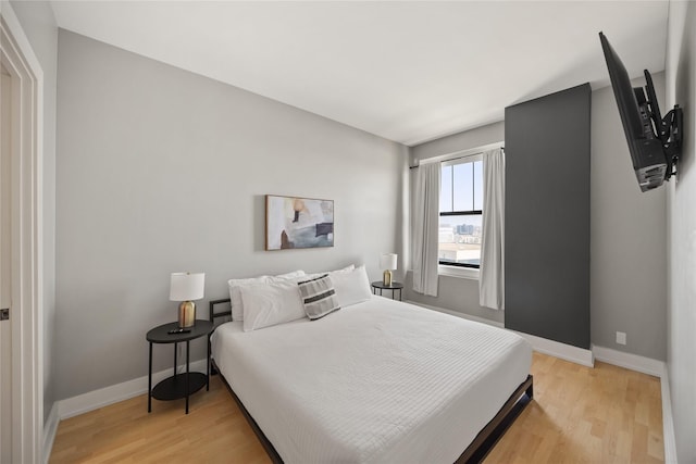 bedroom with light wood-style floors and baseboards