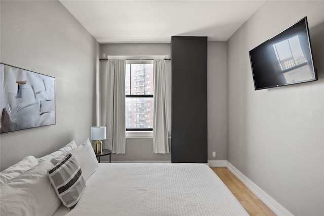 bedroom with light wood-type flooring and baseboards