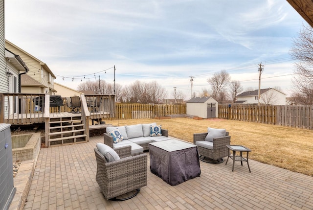 view of patio / terrace with a deck, a fenced backyard, an outdoor structure, an outdoor living space, and a shed