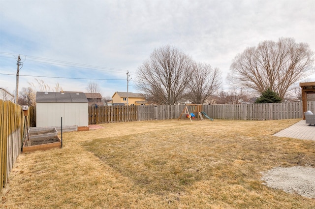 view of yard with an outbuilding, a shed, a playground, and a fenced backyard