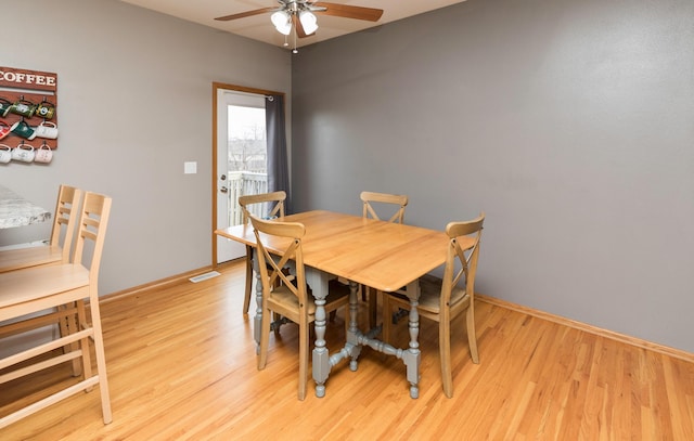 dining space featuring ceiling fan, light wood finished floors, and baseboards