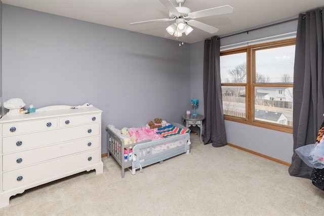 bedroom with a ceiling fan, light colored carpet, and baseboards