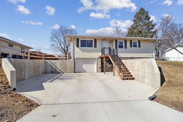 view of front of house with a garage, driveway, stairway, and fence