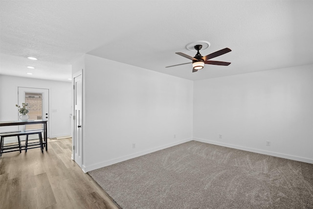 spare room featuring light wood finished floors, baseboards, recessed lighting, a textured ceiling, and a ceiling fan