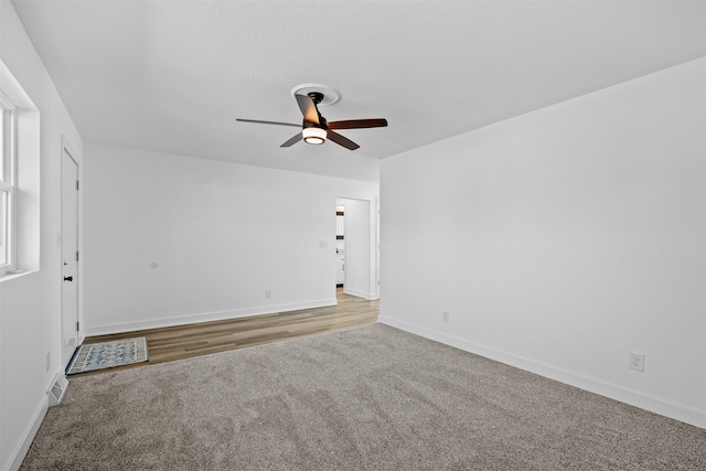 spare room with visible vents, ceiling fan, baseboards, and carpet