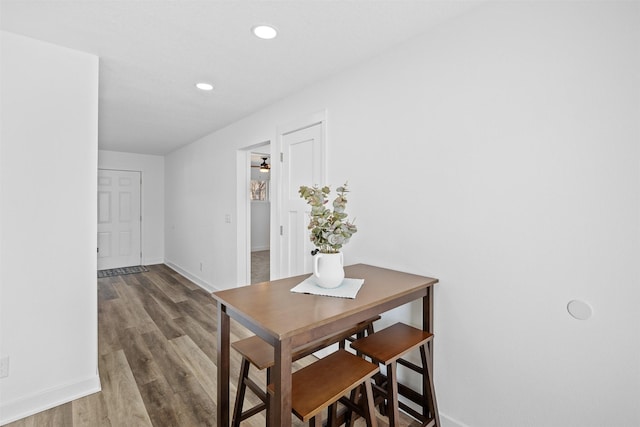 dining room with recessed lighting, wood finished floors, and baseboards