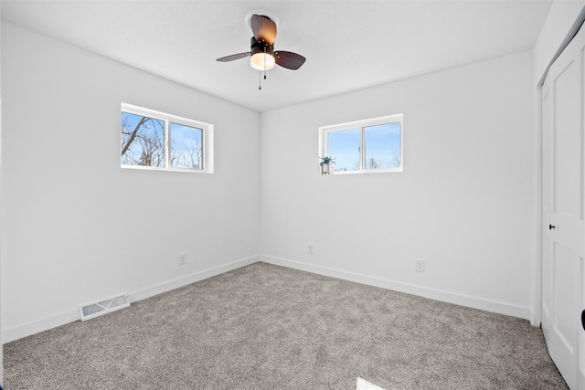 unfurnished bedroom with visible vents, multiple windows, and carpet floors